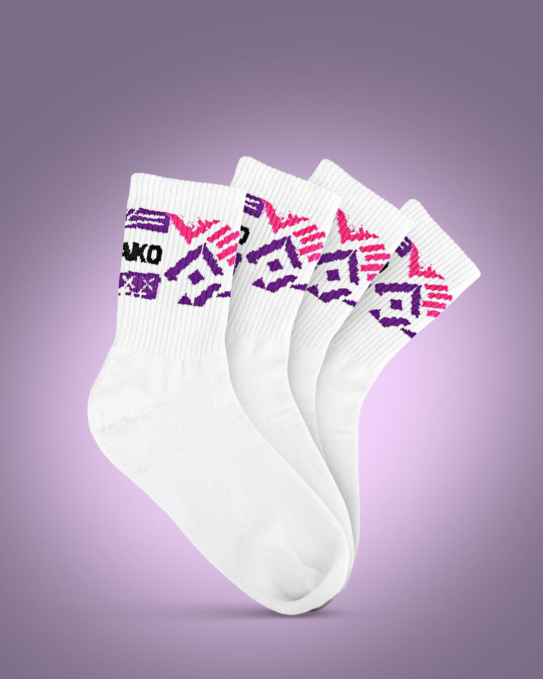 Rückansicht einer Person mit weißen Sneakern und weißen gerippten Crew-Socken. Die Socken zeigen ein auffälliges Design mit dem schwarzen Schriftzug „JAKO“ sowie grafischen Elementen in Lila und Pink. Die Schuhe sind ebenfalls weiß und schlicht gestaltet. Der Hintergrund ist hell und neutral, sodass der Fokus auf den Socken liegt.