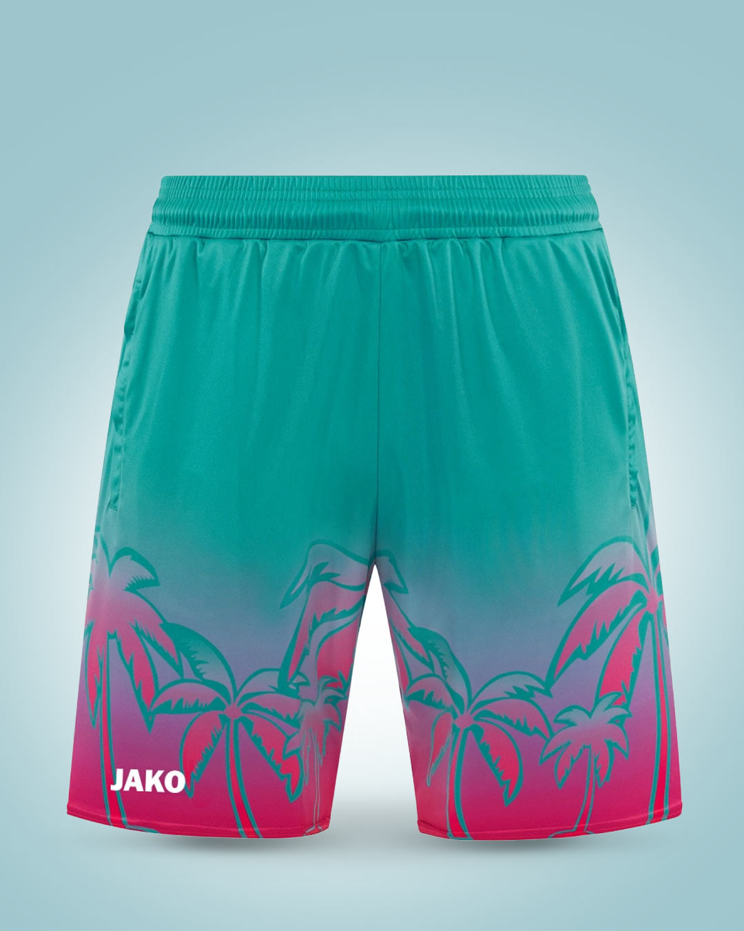 Türkis-pinke JAKO Shorts mit Palmenmotiv auf türkisfarbenem Hintergrund.